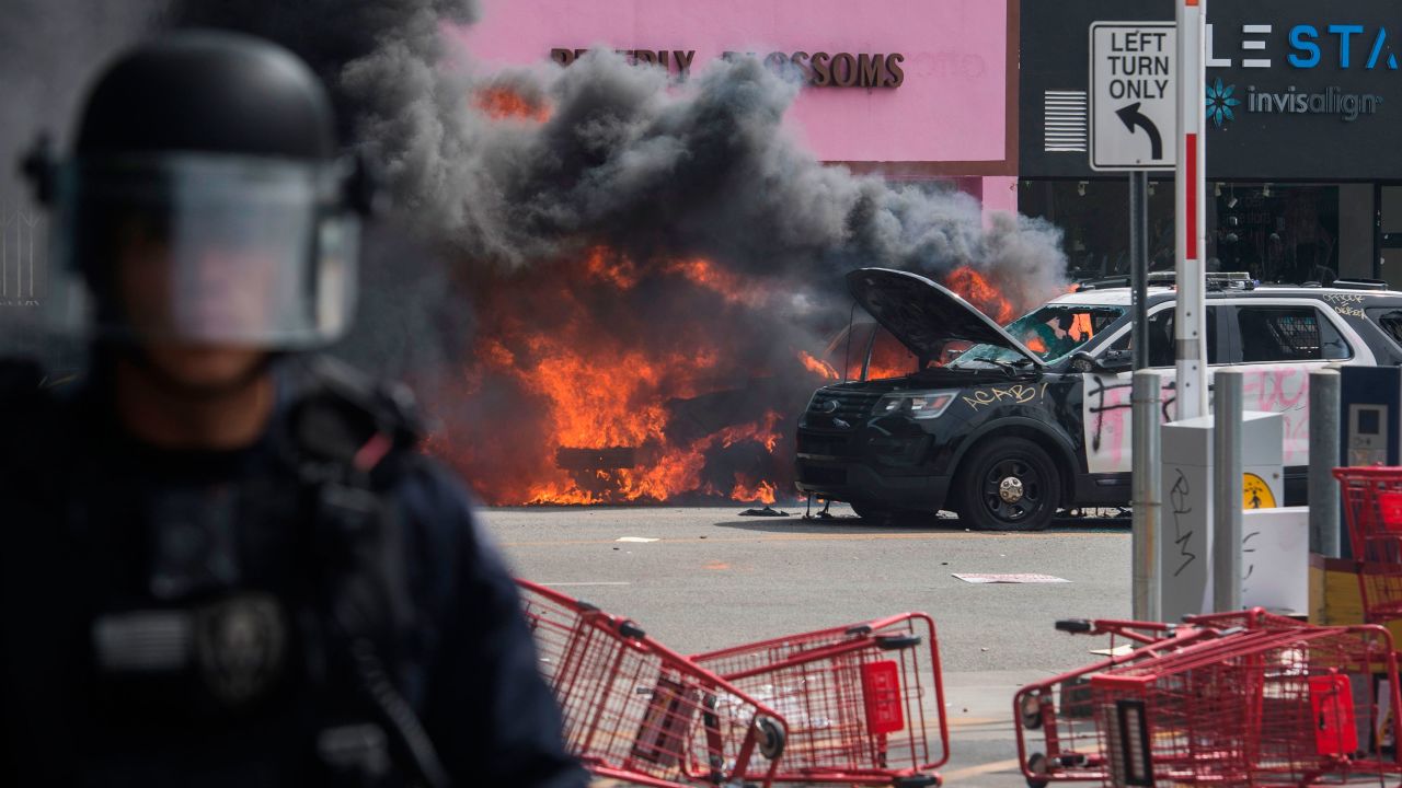 Police vehicles burn after being set on fire by demonstrators in the Fairfax District on May 30, 2020, in Los Angeles