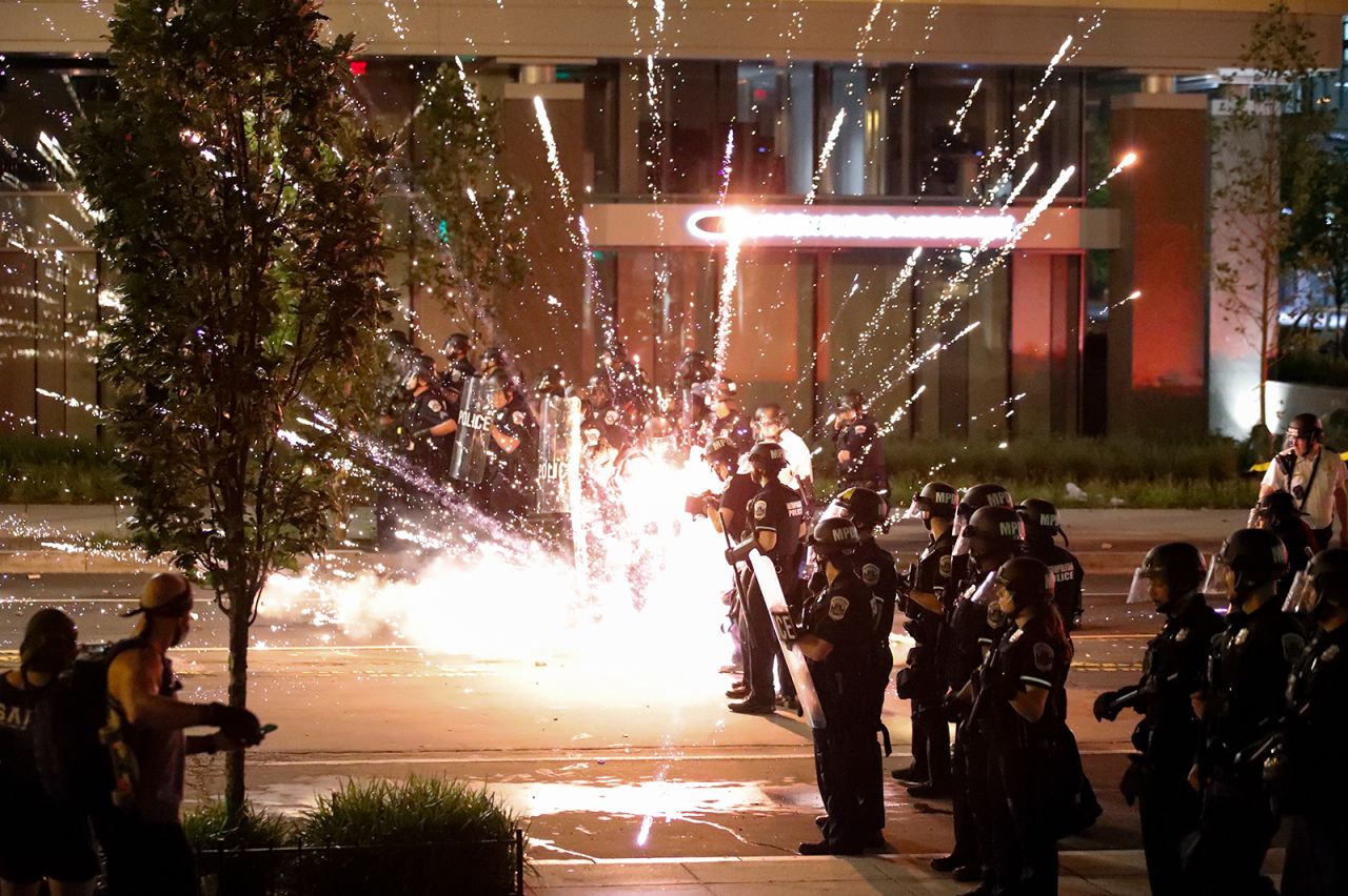 A firework explodes by a police line near the White House on May 30.