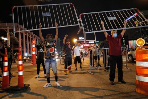 Protesters hold up metal gates as they build a barrier on a Las Vegas roadway on May 30.