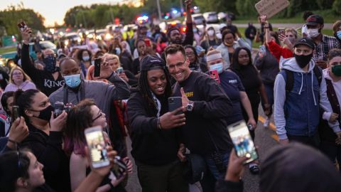 Johnie Franklin of Flint takes a selfie with Genesee County Sheriff Chris Swanson as he marches with protesters against police brutality and in memory of George Floyd on Saturday in Flint Township, Michigan.