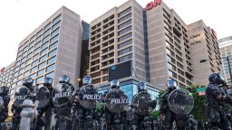 Police stand guard around the CNN Center and Centennial Olympic park as protests continue over the death of George Floyd, Saturday, May 30, 2020, in Atlanta. Protests were held in U.S. cities over the death of Floyd, a black man who died after being restrained by Minneapolis police officers on May 25. 