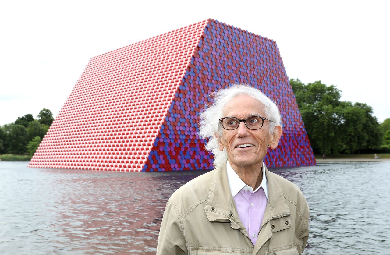 The artist Christo poses in front of "The London Mastaba" in June 2018. The 20 meter-high installation comprised of more than 7,500 oil barrels floating on a lake in Hyde Park.