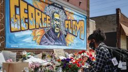 Malaysia Hammond, 19, places flowers at a memorial mural for George Floyd at the corner of Chicago Avenue and 38th Street, Sunday, May 31, 2020, in Minneapolis. Protests continued following the death of George Floyd, who died after being restrained by Minneapolis police officers on Memorial Day. (AP Photo/John Minchillo)
