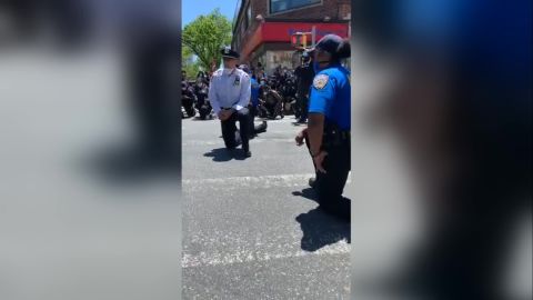 Some New York City police officers surprised protesters Sunday by kneeling with them. 