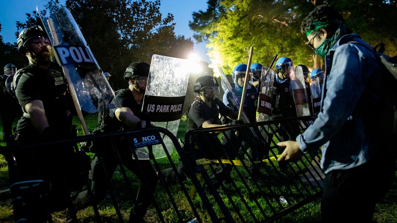 Police move forward to raise a barrier that the protestors had knocked down in front of the White House as they protest the death of George Floyd at the hands of Minneapolis Police in Washington, D.C. on May 31, 2020. - Thousands of National Guard troops patrolled major US cities after five consecutive nights of protests over racism and police brutality that boiled over into arson and looting, sending shock waves through the country. The death Monday of an unarmed black man, George Floyd, at the hands of police in Minneapolis ignited this latest wave of outrage in the US over law enforcement's repeated use of lethal force against African Americans -- this one like others before captured on cellphone video.