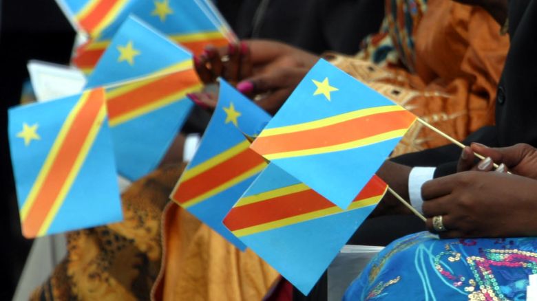 Congolese ladies hold paper replicas of Democratic Republic of Congo's new flag during a ceremony to mark the signing of a post-war constitution at the presidential palace in the capital Kinshasa February 18, 2006. Democratic Republic of Congo on Saturday adopted a new constitution aimed at bringing an end to decades of dictatorship, war and chaos in the vast country, and paving the way for elections by mid-2006. REUTERS/David Lewis