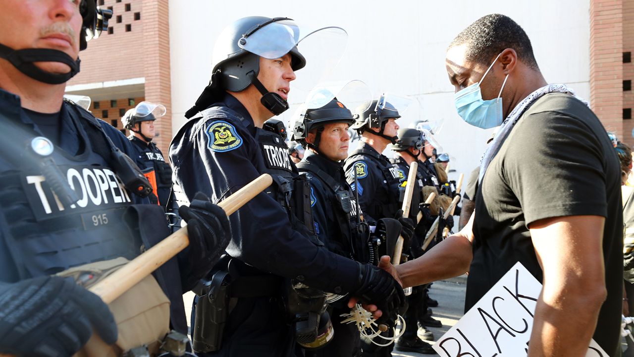 A demonstrator and police officer shake hands in Kansas City, Missouri.