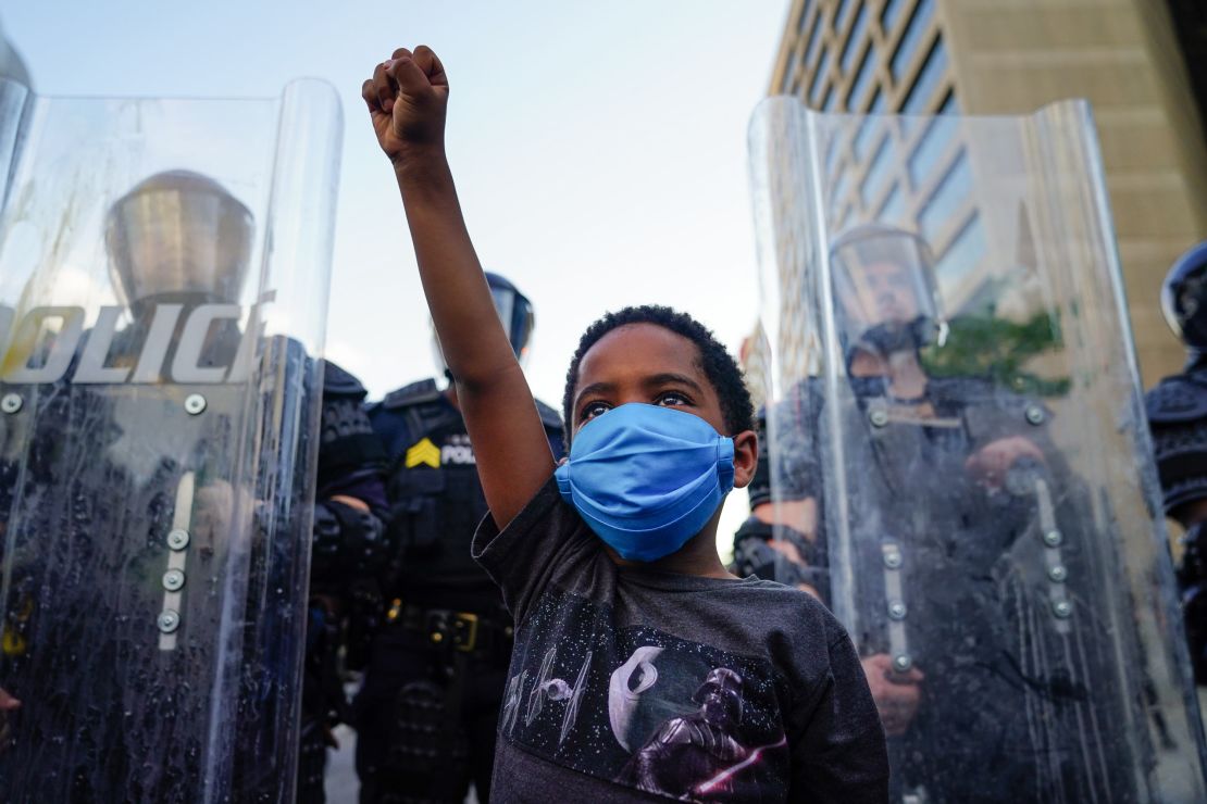 A young boy raises his fist for a photo by a family friend during a demonstration on May 31 in Atlanta, Georgia. 