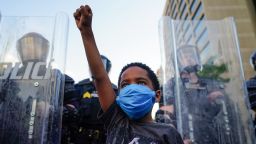 ATLANTA, GA - MAY 31: A young boy raises his fist for a photo by a family friend during a demonstration on May 31, 2020 in Atlanta, Georgia. Across the country, protests have erupted following the recent death of George Floyd while in police custody in Minneapolis, Minnesota. (Photo by Elijah Nouvelage/Getty Images)