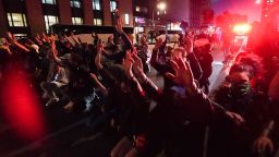 Protesters take a knee and raise their hands in the middle of Canal Street in a stand off with police over the death of George Floyd by a Minneapolis police officer at a rally on May 31, 2020 in New York. - Thousands of National Guard troops patrolled major US cities  after five consecutive nights of protests over racism and police brutality that boiled over into arson and looting, sending shock waves through the country. The death Monday of an unarmed black man, George Floyd, at the hands of police in Minneapolis ignited this latest wave of outrage in the US over law enforcement's repeated use of lethal force against African Americans -- this one like others before captured on cellphone video. (Photo by Bryan R. Smith / AFP) (Photo by BRYAN R. SMITH/AFP via Getty Images)
