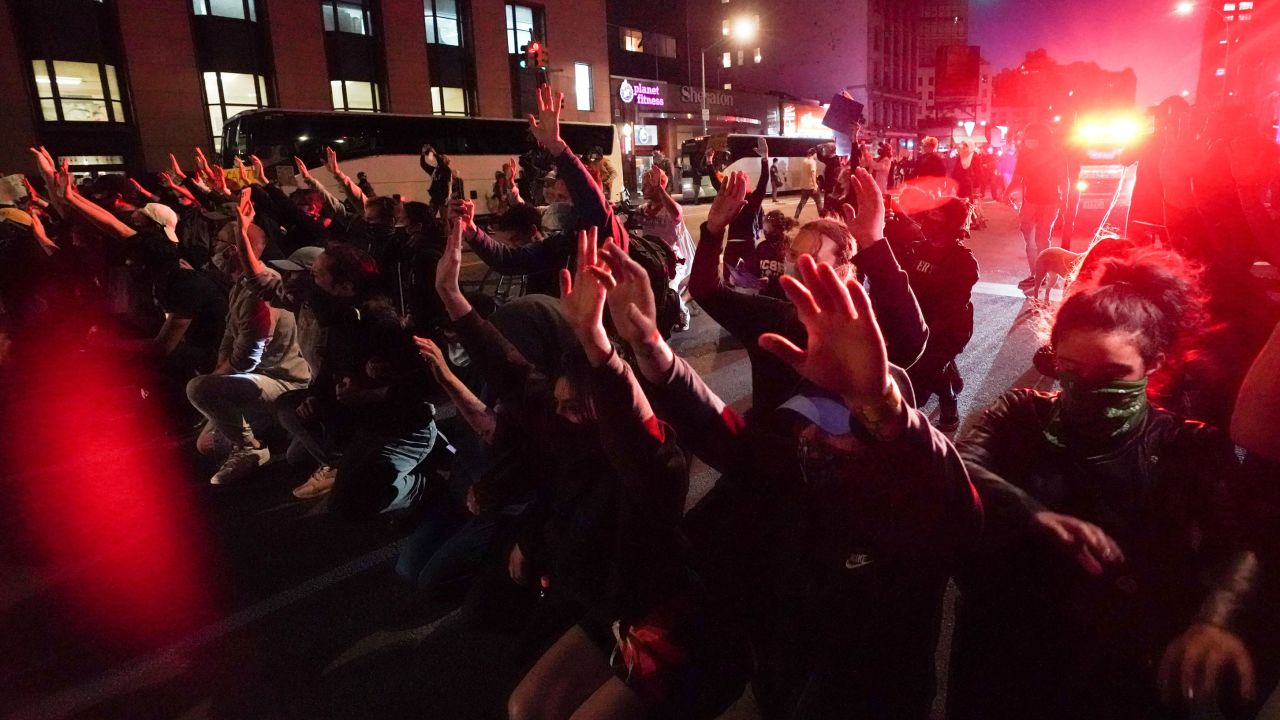 Protesters take a knee and raise their hands in the middle of New York's Canal Street on May 31 in a standoff with police over the death of George Floyd.