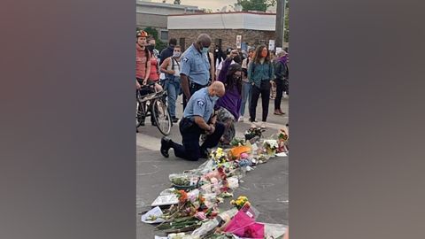 Minneapolis Police Chief Medaria Arradondo kneels at a memorial for George Floyd outside the Cup Foods store in south Minneapolis.