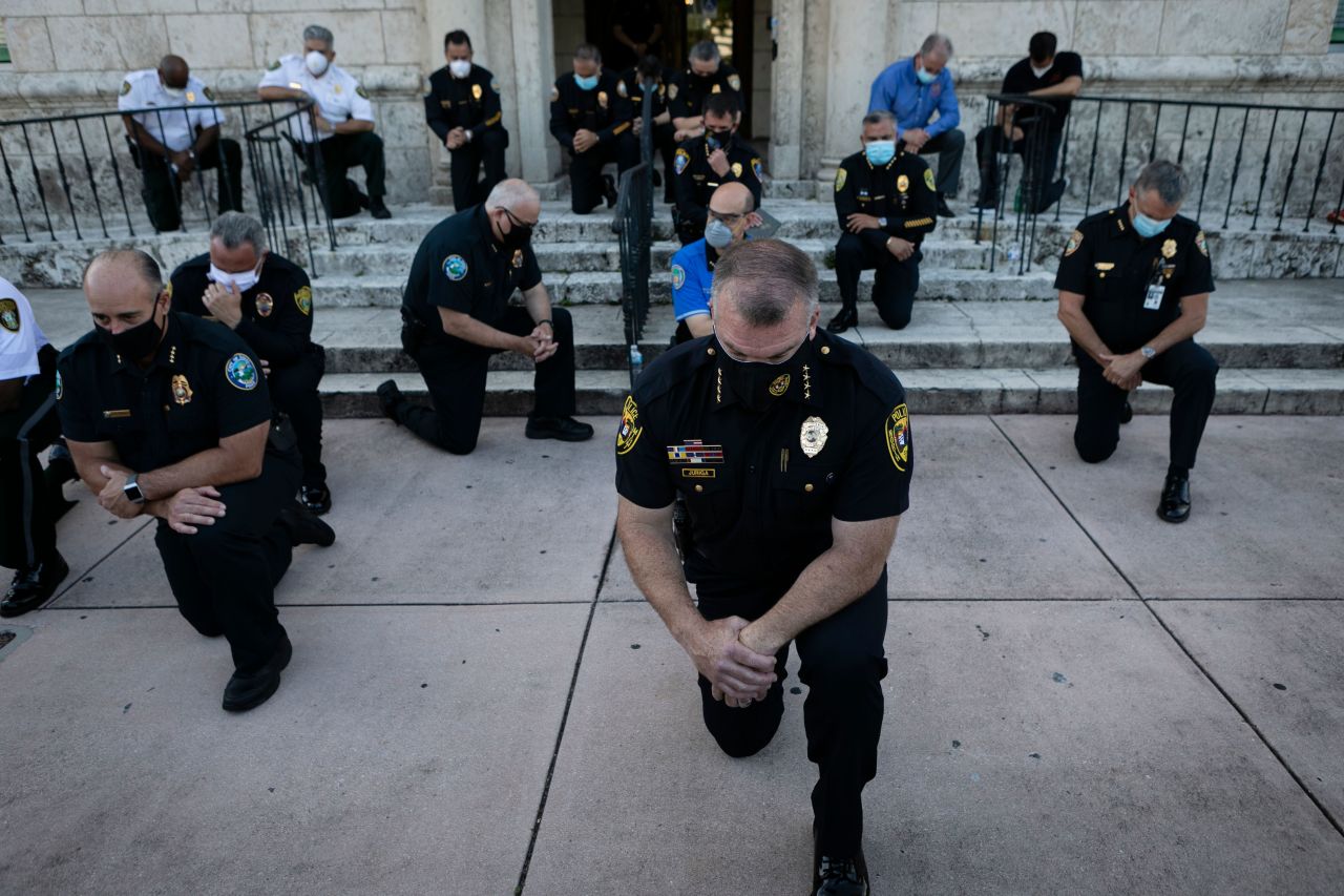 Police officers kneel during a rally in Coral Gables, Florida, on May 30.