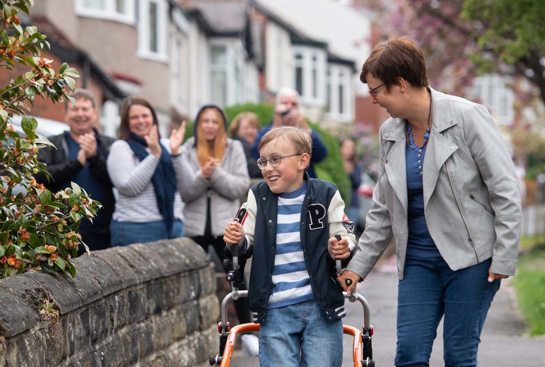 Tobias is cheered on by neighbors as he walks along his street in Sheffield, northern England. 