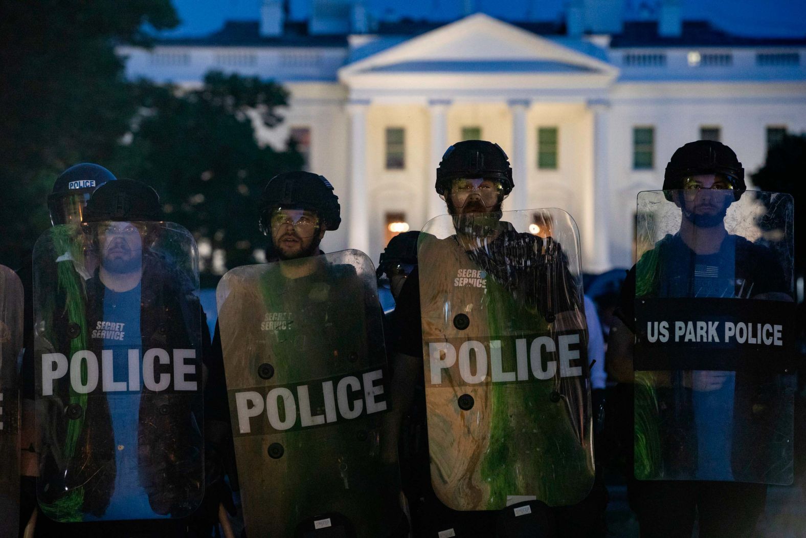 Police stand guard outside the White House as people gather to protest on May 31.