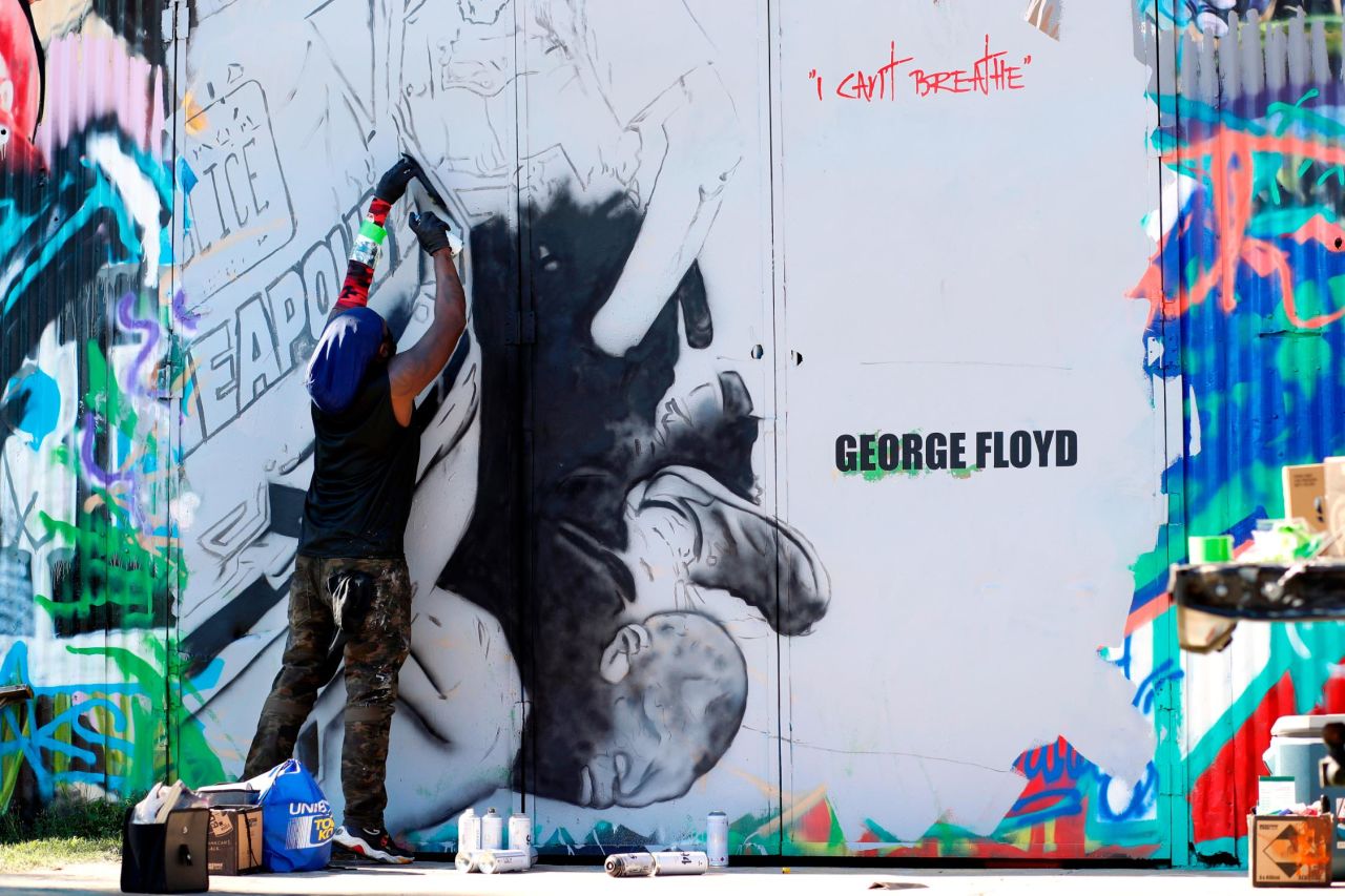 Artist Theo Ponchaveli works on a mural of George Floyd, in Dallas, Texas. 