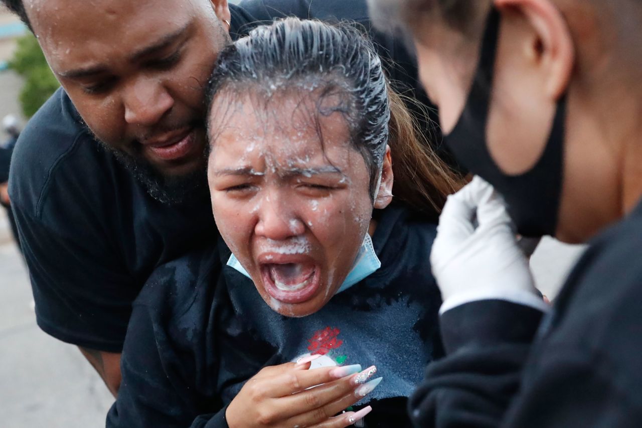 A woman is helped after being hit with pepper spray in Minneapolis on May 31.