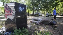 ADDS INFORMATION ON STATUE - An unidentified man walks past a toppled statue of Charles Linn, a city founder who was in the Confederate Navy, in Birmingham, Ala., on Monday, June 1, 2020, following a night of unrest. People shattered windows, set fires and damaged monuments in a downtown park after a protest against the death of George Floyd. Floyd died after being restrained by Minneapolis police officers on May 25. 
(AP Photo/Jay Reeves)