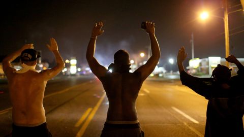 Demonstrators raise their arms as they protest the shooting death of Michael Brown on August 17, 2014 in Ferguson, Missouri.