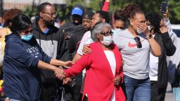 Odessa  Riley, center in red sweater, was escorted by family members June 1 to the site where her son was fatally shot at 26th and Broadway in Louisville, Ky.