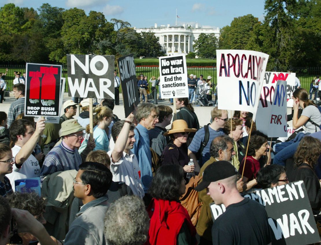 Anti-war protesters march past the White House in Washington, DC, on October 26, 2002, to protest President George W. Bush's policy advocating war against Iraq.