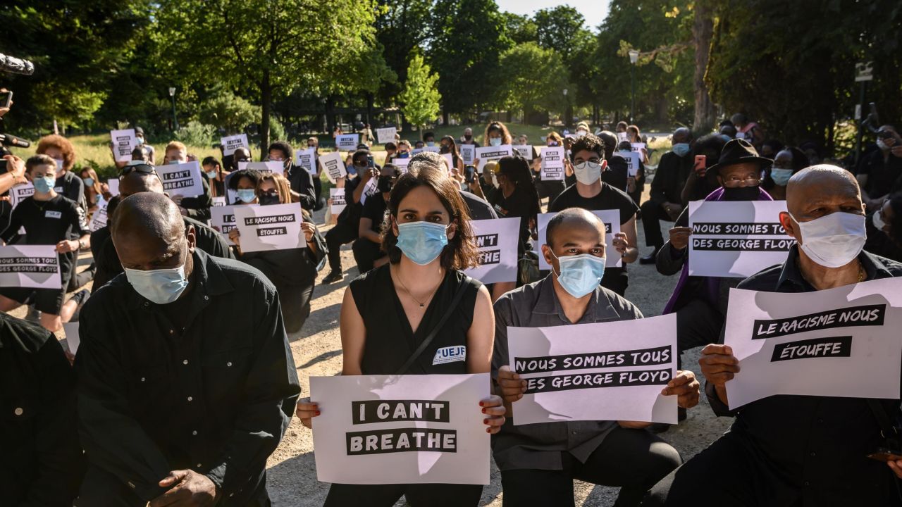 Protesters hold placards including two reading "We are all George Floyd" (2nd R) and "Racism is suffocating us" (R) during a demonstration outside the United States Embassy in Paris on June 1, 2020, after the police killing of unarmed black man George Floyd in the USA. - The United States has erupted into days and nights of protests, violence, and looting, following the death of George Floyd after he was detained and held down by a knee to his neck, dying shortly after. (Photo by BERTRAND GUAY / AFP) (Photo by BERTRAND GUAY/AFP via Getty Images)