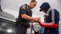 A Connecticut State Trooper prays with a protester in the middle of Interstate 84 after it was closed down during demonstrations in Hartford Monday.