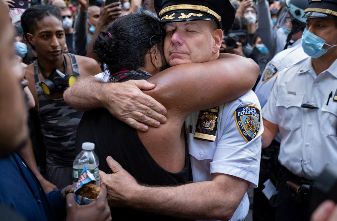 Chief of Department of the New York City Police, Terence Monahan, hugs an activist.