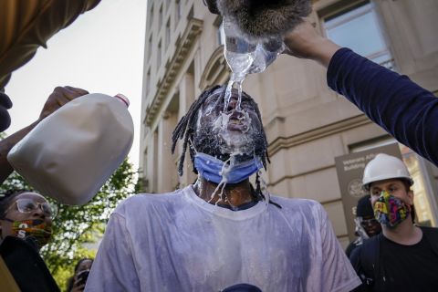A protester is doused with water and milk after being hit with pepper spray from law enforcement in Washington, DC, on June 1.