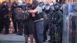 A police officer embraces a protester who helped disperse a crowd of people during a demonstration Monday, June 1, 2020, in Atlanta over the death of George Floyd, who died after being restrained by Minneapolis police officers on May 25. (AP Photo/John Bazemore)