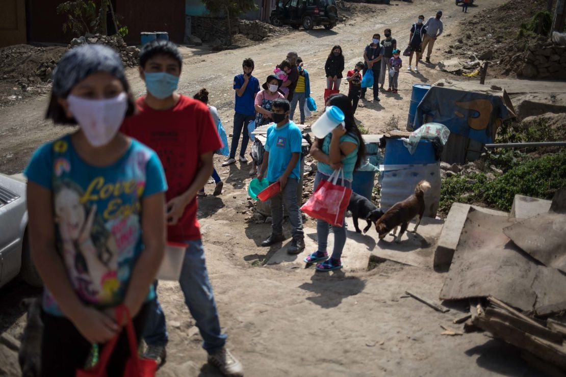 Residents stand in a line at a soup kitchen on the outskirts of Lima, Peru, on Friday, May 29.