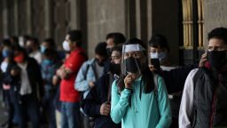 People wearing masks due to the new coronavirus pandemic wait for the mayor's office to open in Mexico City on Monday, June 1.