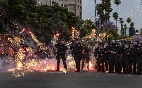 A firework thrown by a protester explodes at the feet of police in Riverside, California, on June 1.