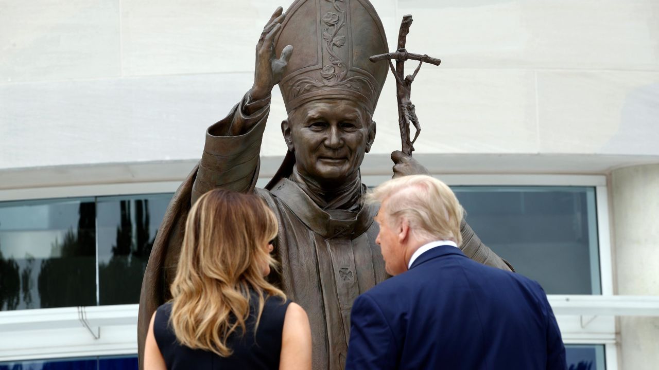 President Trump and first lady Melania Trump view a statue of Pope John Paul II on Tuesday in Washington.