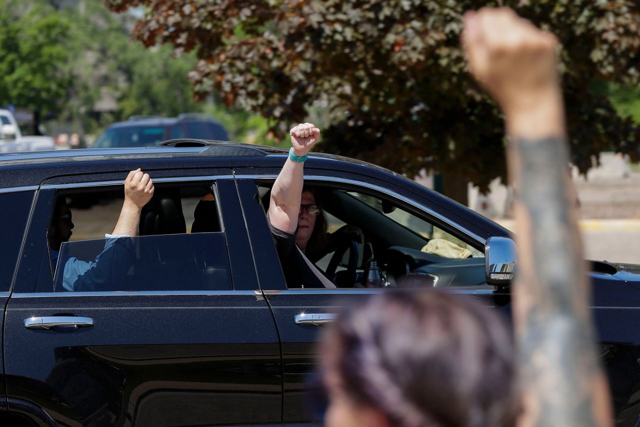 Passengers hold up their fists in solidarity with protesters as they drive by the Wood County Courthouse in Wisconsin Rapids, Wisconsin, on June 2.