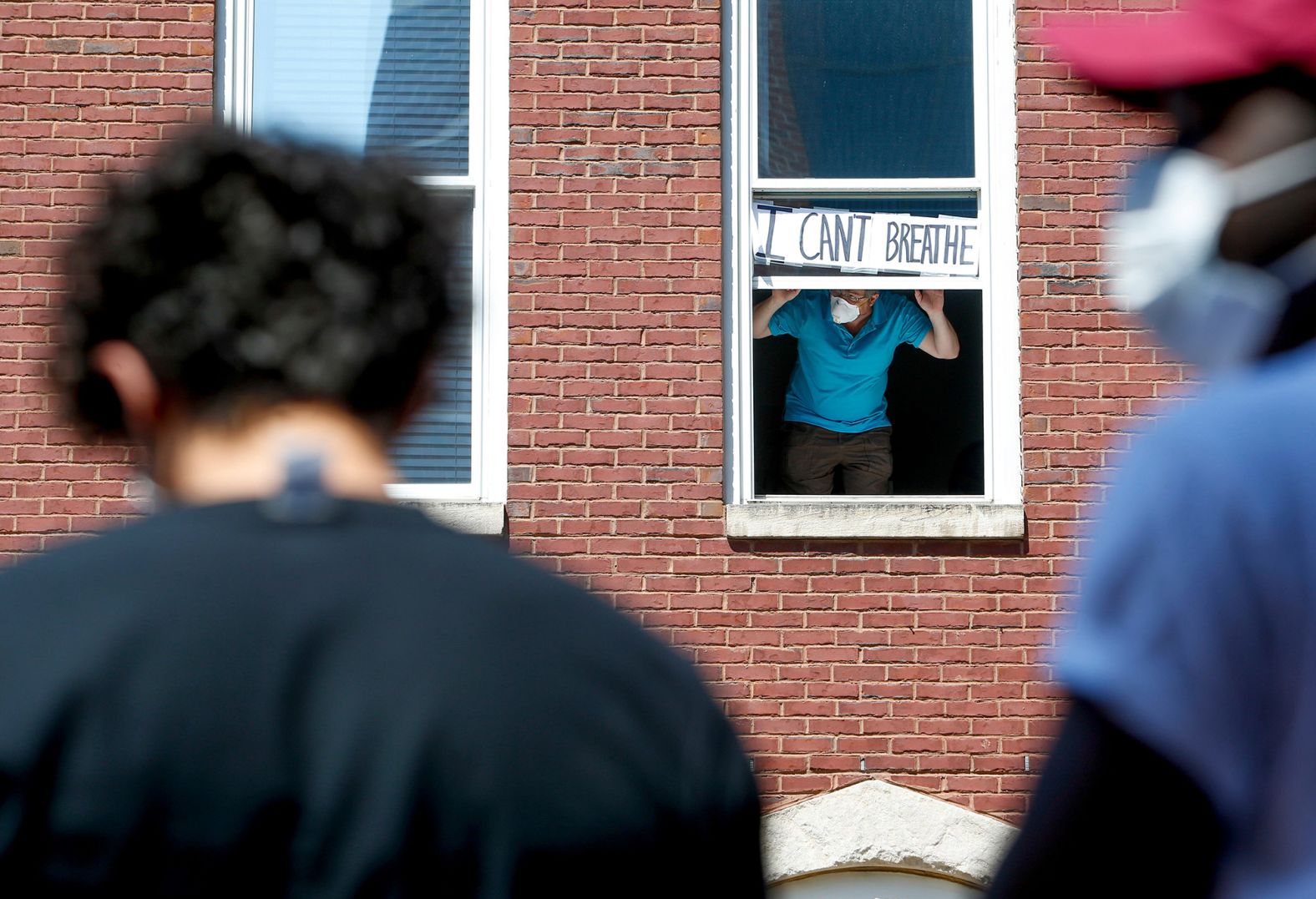 A resident of Clarksville, Tennessee, holds up a sign that says "I can't breathe" across the street from protesters on June 2.