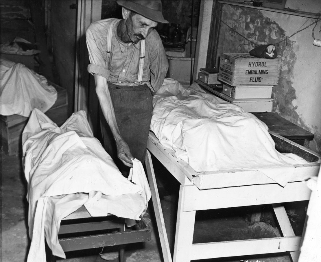 Coroner W.T. Brown places a sheet over the body of one of four Moore's Ford lynching victims in 1946. 