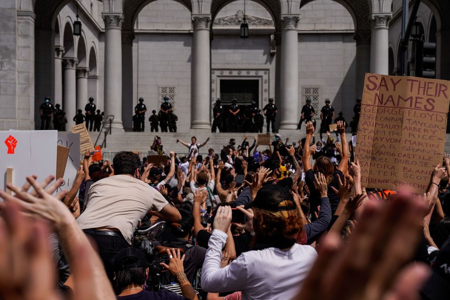Demonstrators raise their hands in the air while protesting in front of City Hall in Los Angeles on June 2.