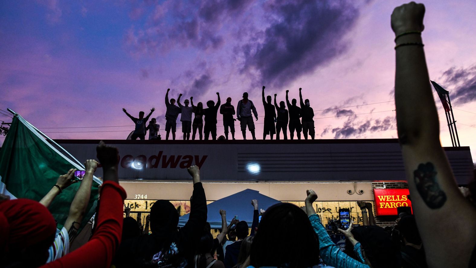 People in Minneapolis raise their hands and shout slogans on June 2 as they protest at the makeshift memorial for George Floyd.