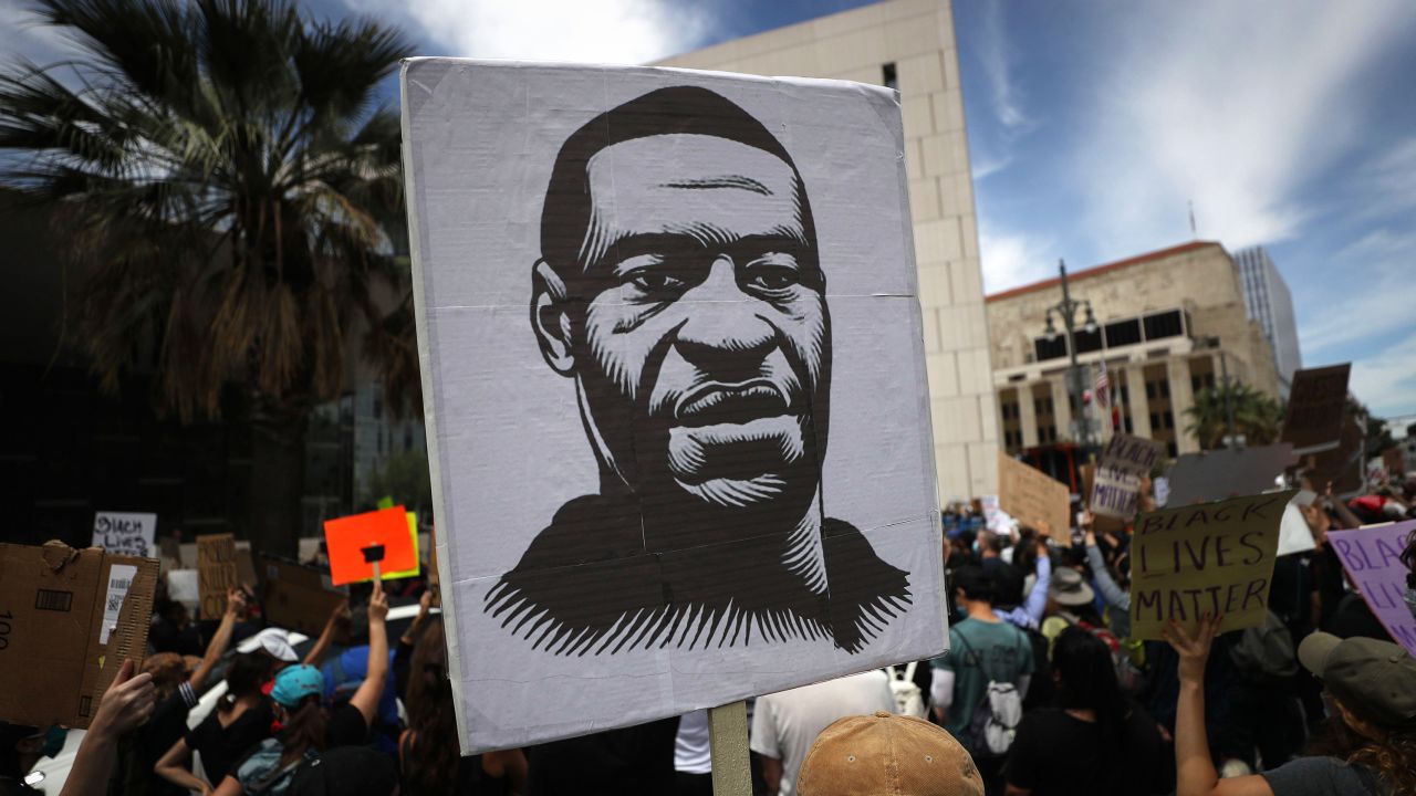 A protester holds a sign with an image of George Floyd during a peaceful demonstration over George Floyd's death outside LAPD headquarters on June 2, 2020 in Los Angeles.