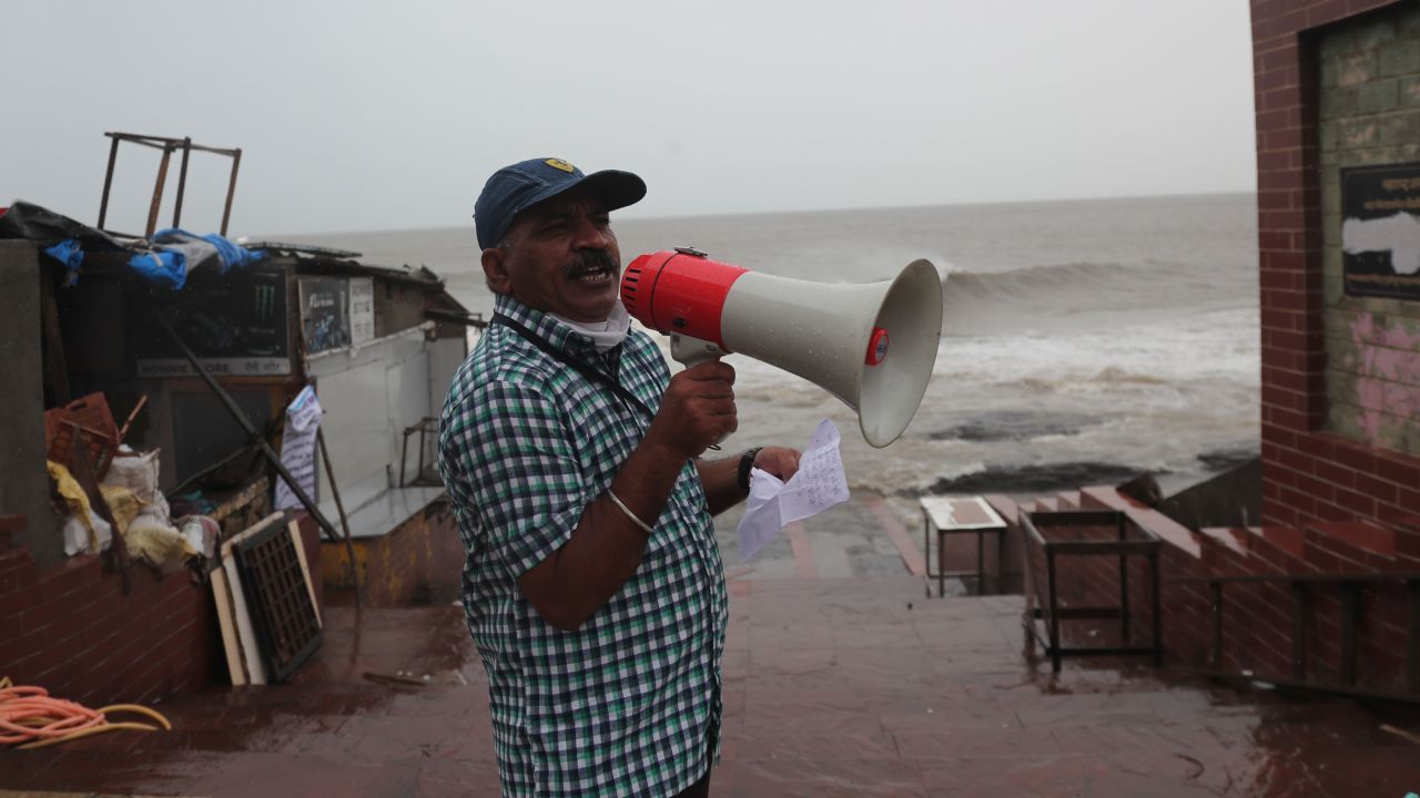 A municipal employee makes a warning announcement by the shore of the Arabian Sea in Mumbai, India, June 3.