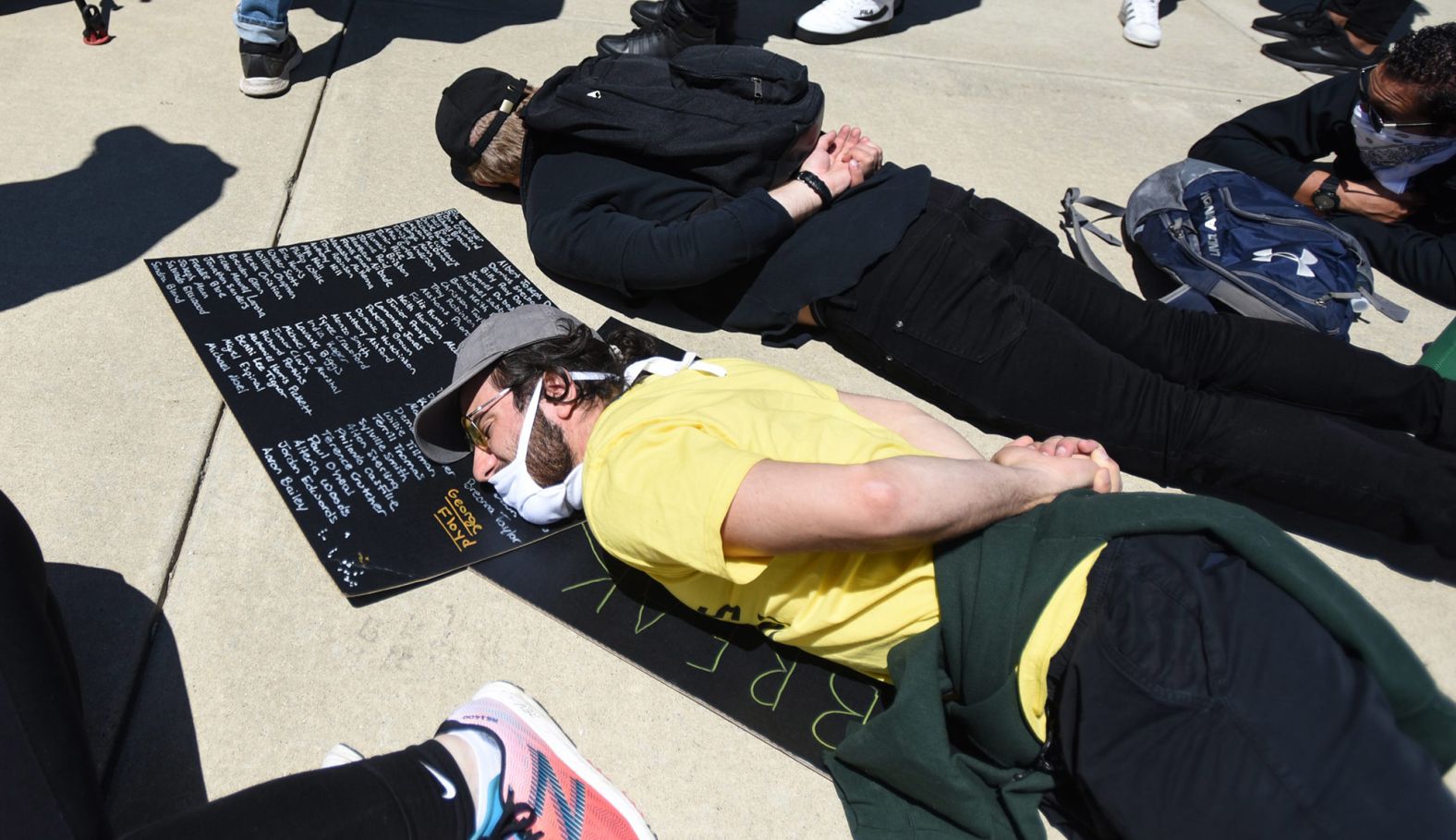 People lie down during a rally at the State Capitol in Lansing, Michigan, on Sunday, May 31.