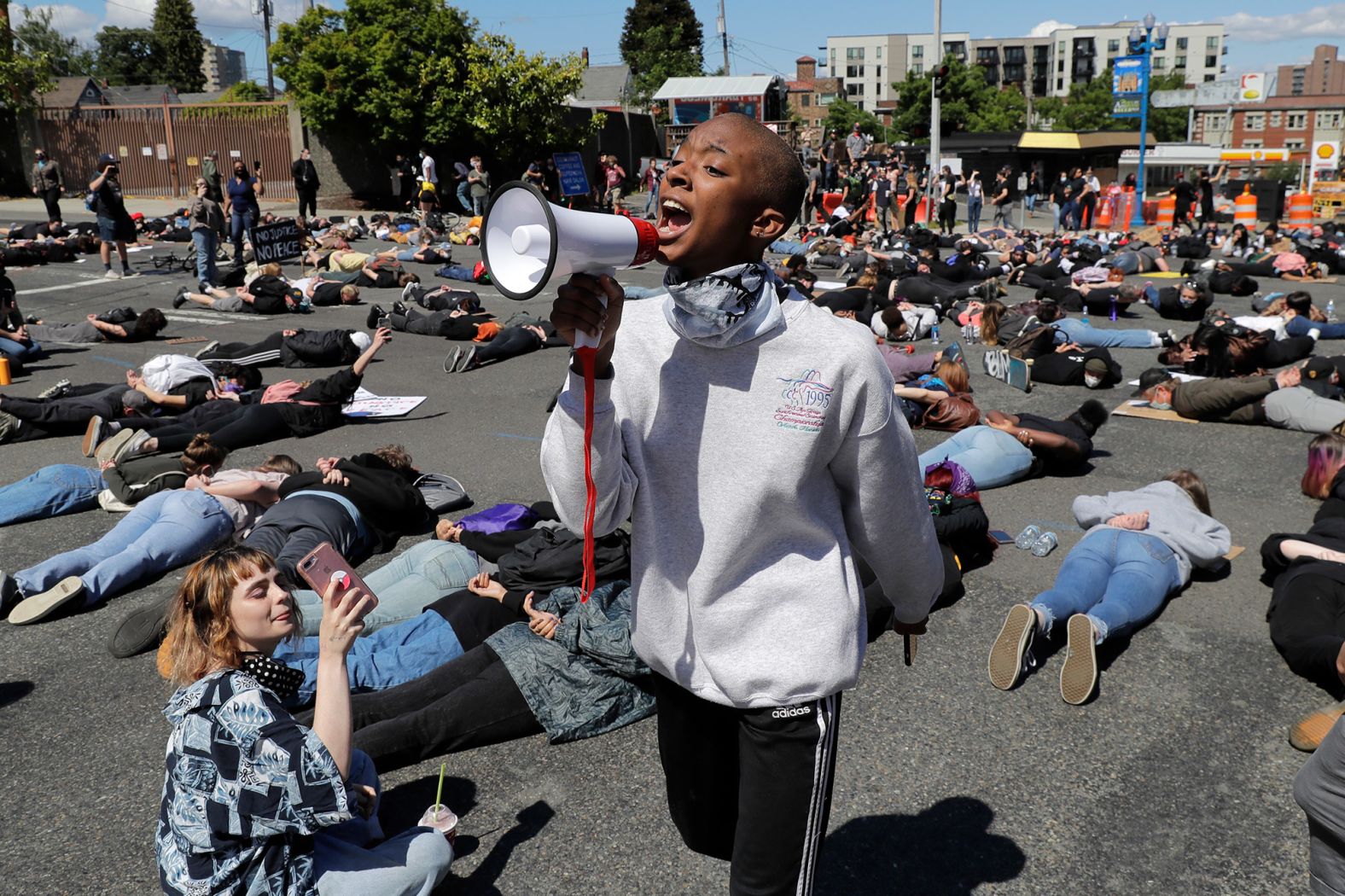 A protester leads chants with a megaphone as others block traffic while lying face-down on the street in Tacoma, Washington, for 8 minutes and 46 seconds on Monday, June 1. That's how long a police officer had his knee on Floyd's neck.