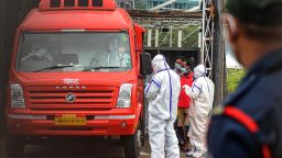 Medical staff wearing personal protective equipments (PPE) oversee COVID-19 patients boarding an ambulance as they are shifted from a field hospital to a another facility ahead of a cyclonic storm that may hit the North Maharashtra and Gujarat coast, in Mumbai on June 2, 2020. - More than 10,000 people, including some coronavirus patients, were moved to safer locations on June 2 as India's west coast braced for a cyclone, the first such storm to threaten Mumbai in more than 70 years. (Photo by VIJAY BATE / AFP) (Photo by VIJAY BATE/AFP via Getty Images)