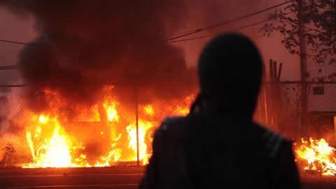 A person in Minneapolis, Minnesota watches vehicles burn during a May 29 protest sparked by the death of George Floyd.