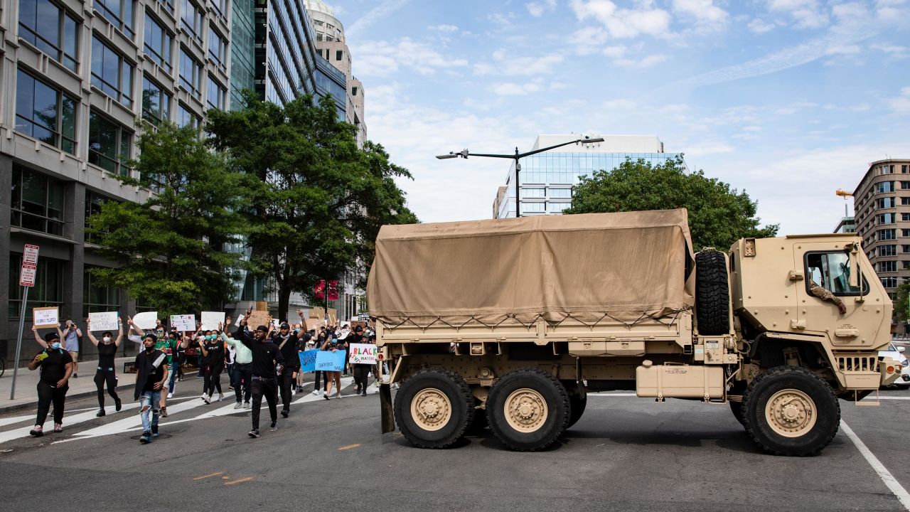 In this June 2, 2020, file photo, protesters pass DC National Guard troops as they march through Washington during demonstrations over the death of George Floyd.
