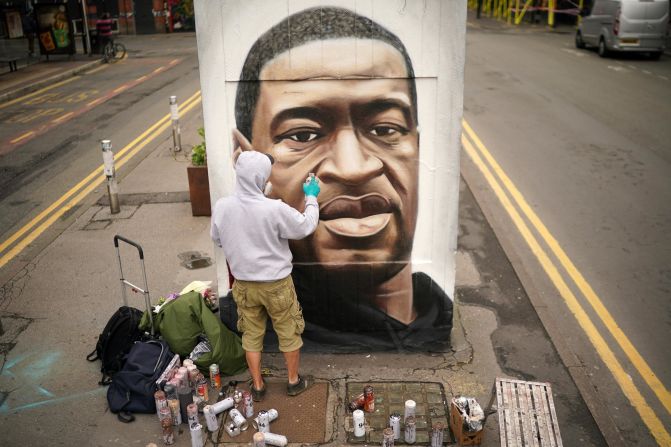 Graffiti artist Akse spray paints a mural of George Floyd in the norther quarter of Manchester, UK. 
