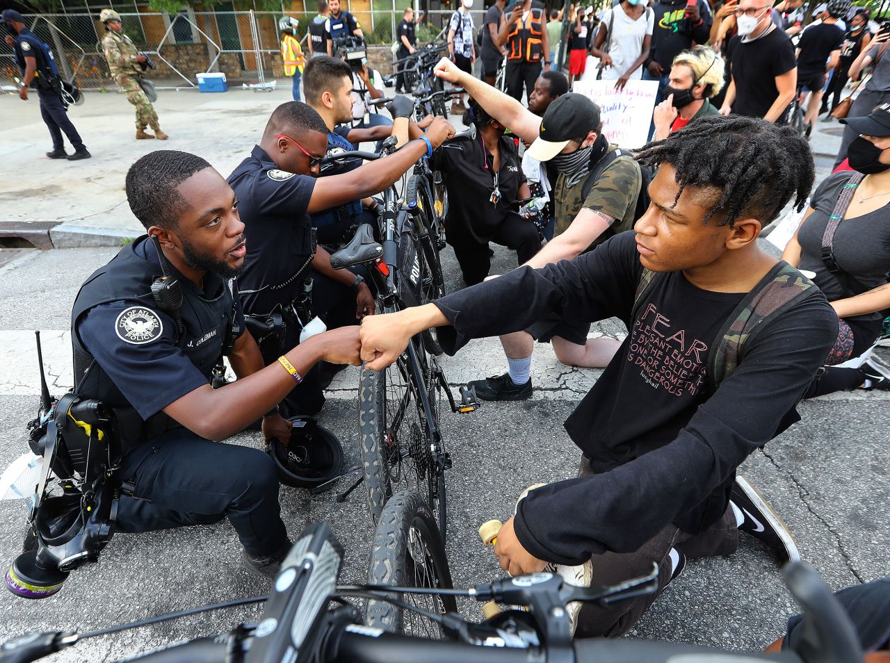 Atlanta Police Officer J. Coleman shares a fist bump with protester Elijah Raffington on June 3. The police bicycle unit was taking a knee with protesters outside the CNN Center.
