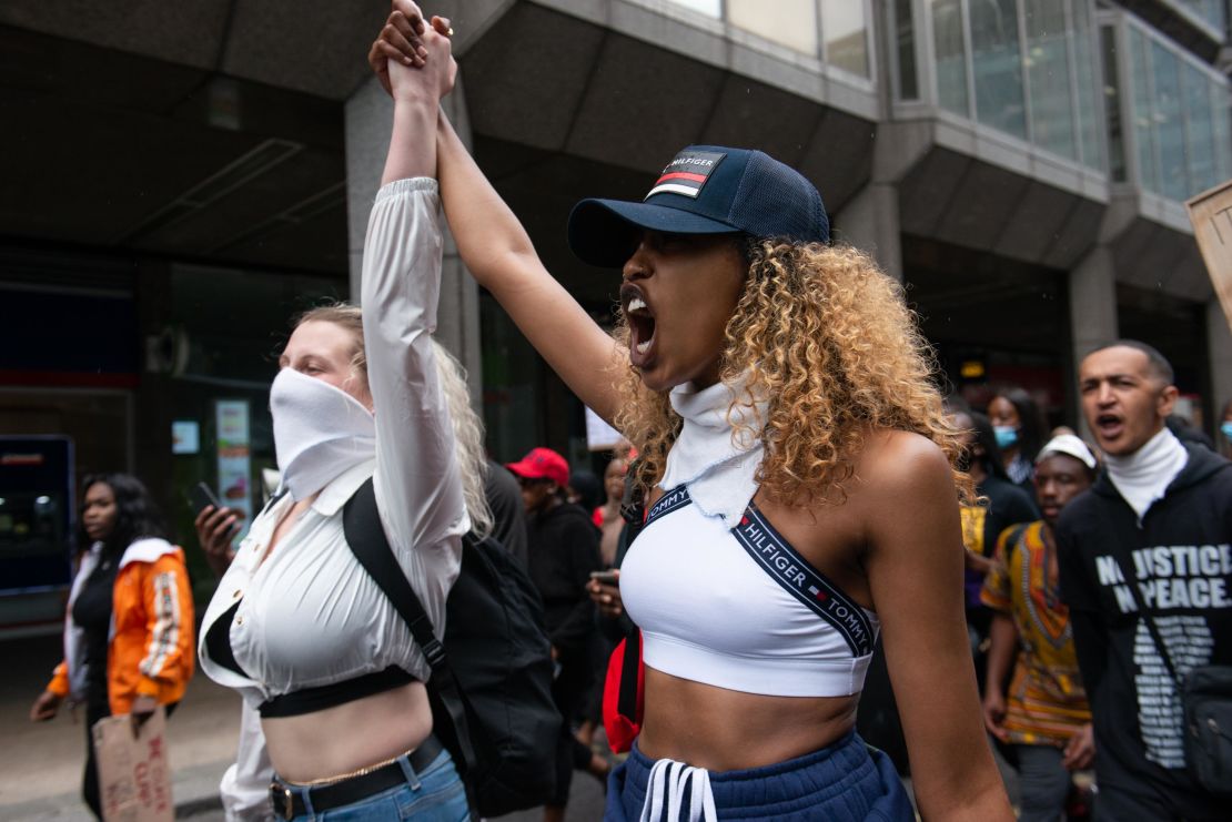 Two protesters join hands as they rally in London.