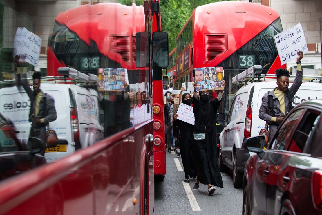 Protesters move between stopped buses and cars as the demonstration moved through central London.
